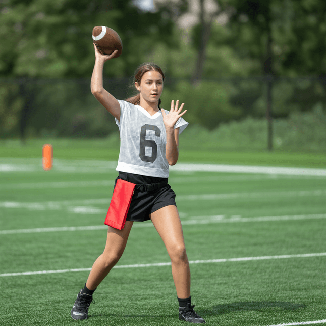 Flag football quarterback throwing a pass on a grass field
